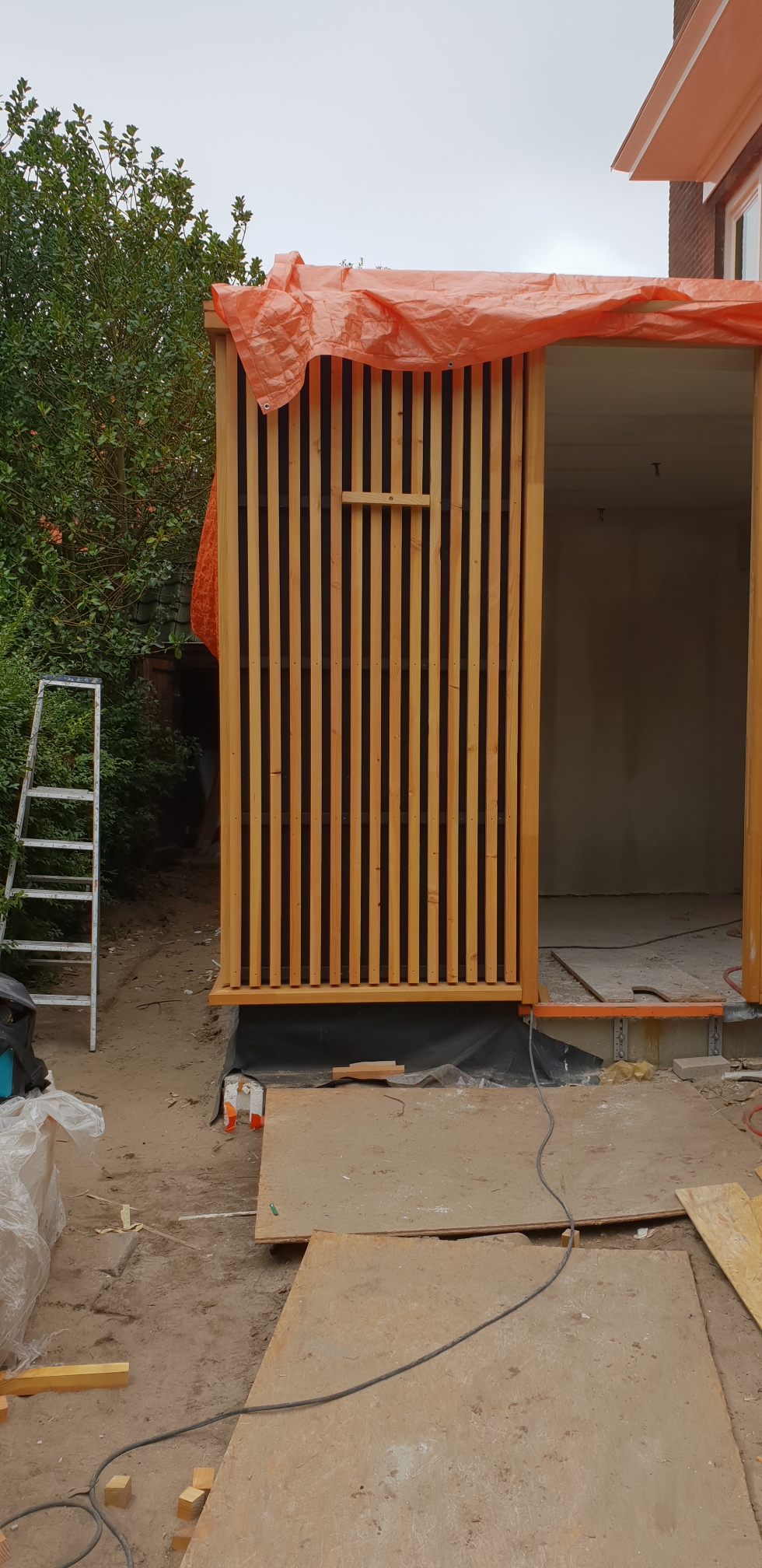 Fundering en betonvloer van een uitbouw in aanbouw achter een woning in Amsterdam